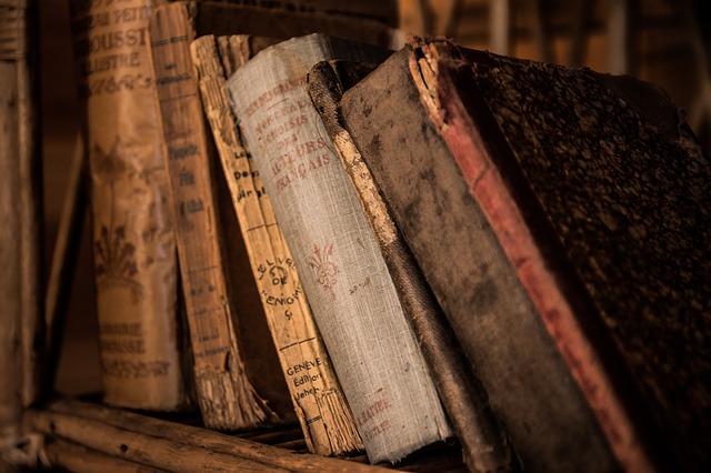 Old boks on a shelf, leaning to the left. Antique books of various colors, sizes. Representing old stories that are of little interest anymore.
